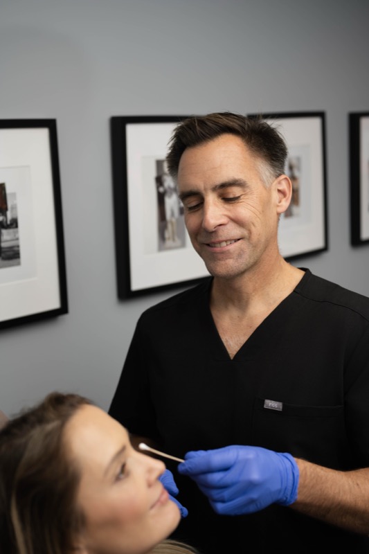 Dr. John Rachel examining patient eye area for blepharoplasty in Chicago